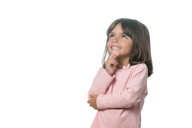 Retrato de una niña rubia pensativa sobre el fondo blanco.