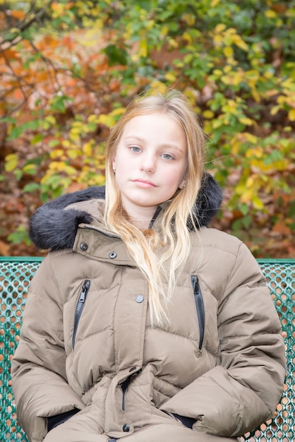 Retrato de niña rubia triste en el banco