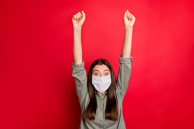 Foto retrato de niña sana con máscara de seguridad levantando las manos buenas noticias recuperación de la gripe