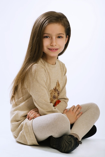 Retrato de niña de siete años sobre fondo blanco.