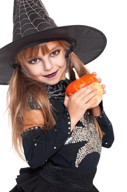 Foto retrato de una niña con sombrero negro con calabaza aislada sobre fondo blanco