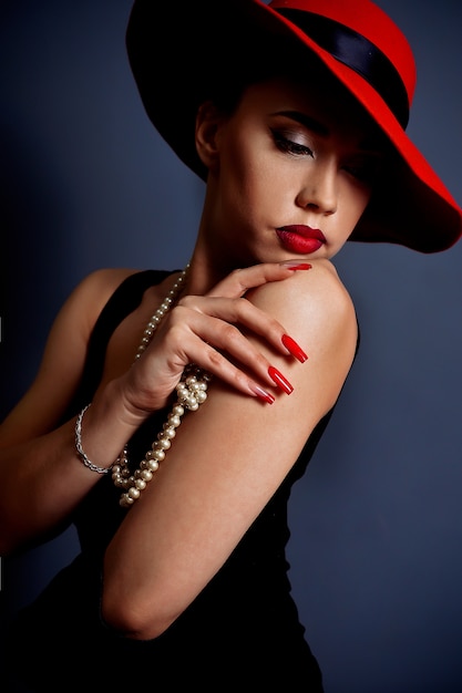 Retrato de una niña con un sombrero rojo con labios rojos