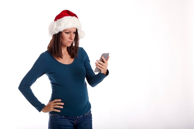 Retrato de una niña con un sombrero de Santa Claus sobre un fondo blanco.