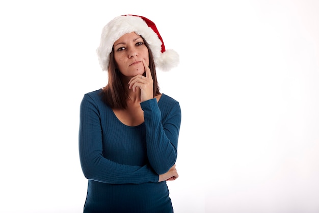 Retrato de una niña con un sombrero de Santa Claus sobre un fondo blanco.