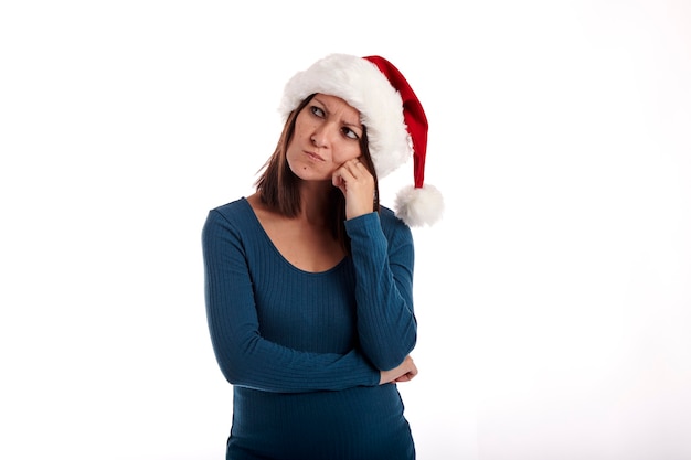 Retrato de una niña con un sombrero de Santa Claus sobre un fondo blanco.