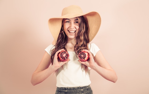 Retrato de una niña en un sombrero de verano con fruta
