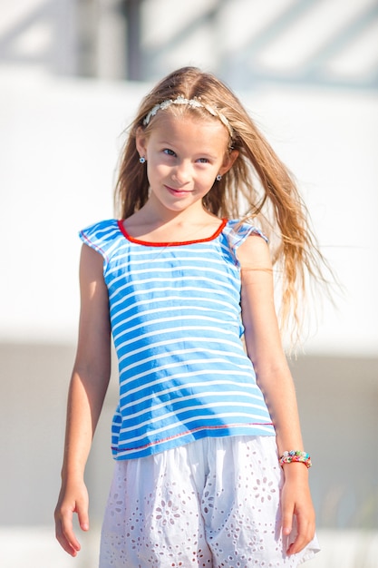 Retrato de niña sonriente adorable en vacaciones en la playa