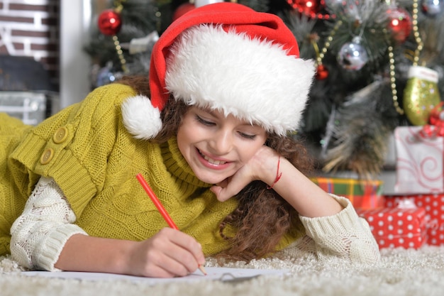 Retrato de niña sonriente escribiendo carta