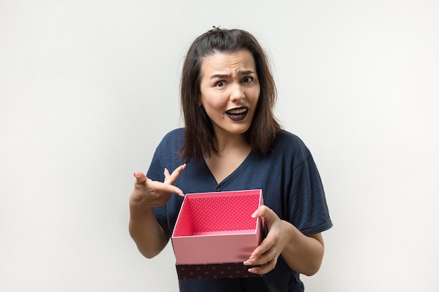 Retrato de una niña sonriente feliz abriendo una caja de regalo aislado sobre fondo blanco.