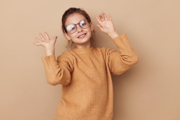 Retrato de niña sonriente feliz con gafas emociones gesto manos estilo de vida inalterado