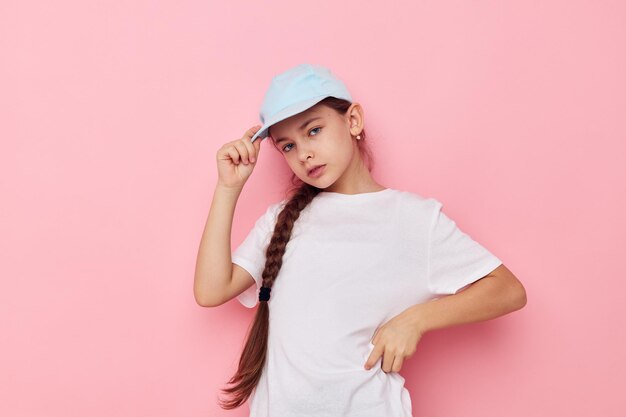 Retrato de niña sonriente feliz posando camiseta blanca emoción fondo rosa