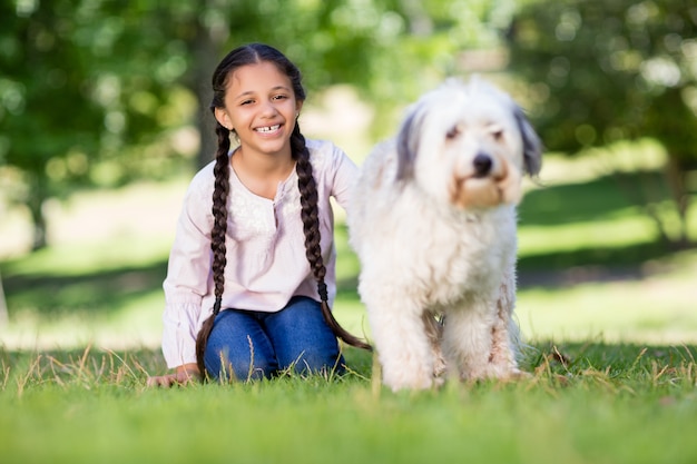 Retrato de niña sonriente jugando con su perro mascota