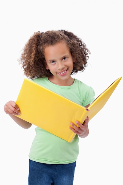 Retrato de una niña sonriente leyendo un cuento de hadas