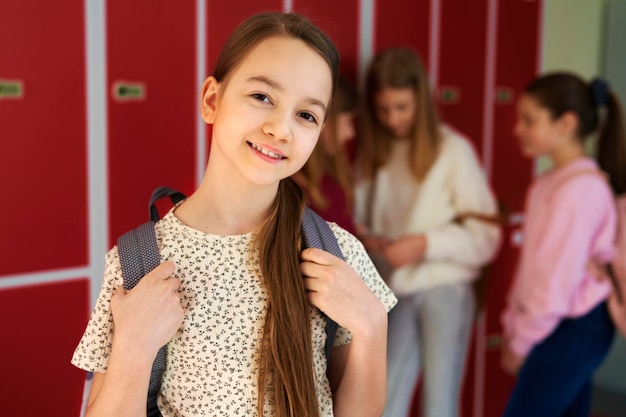 Retrato de una niña sonriente de pie en la escuela