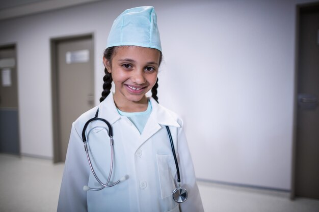 Retrato de niña sonriente pretendiendo ser médico