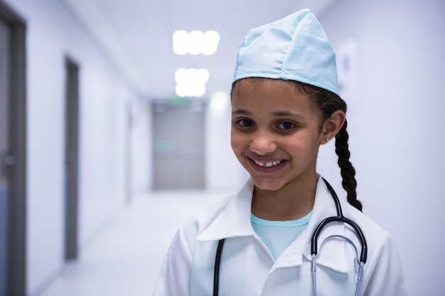 Retrato de niña sonriente pretendiendo ser médico