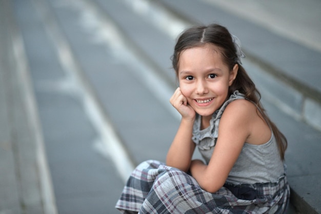 Retrato de niña sonriente sentada en las escaleras