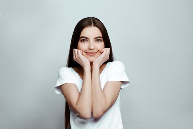 Retrato de una niña sonriente sobre un fondo blanco.