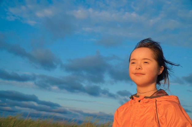 Retrato de niña sonriente sobre fondo de cielo azul