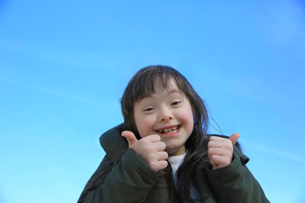 Retrato de niña sonriente sobre fondo de cielo azul