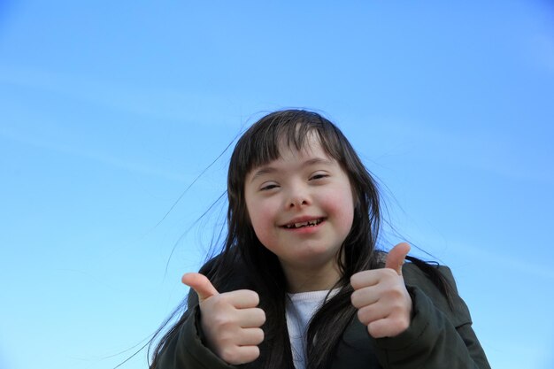 Retrato de niña sonriente sobre fondo de cielo azul