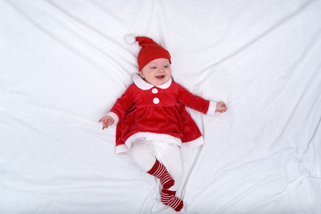 Retrato de niña sonriente en un sombrero de santa y un vestido rojo. Concepto de navidad