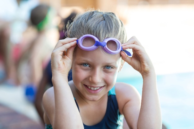 Retrato de niña sonriente sosteniendo gafas de natación