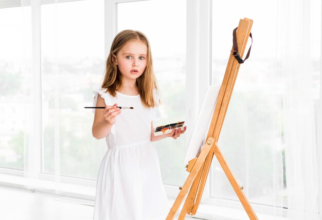 Retrato de niña sorprendida pintando un cuadro