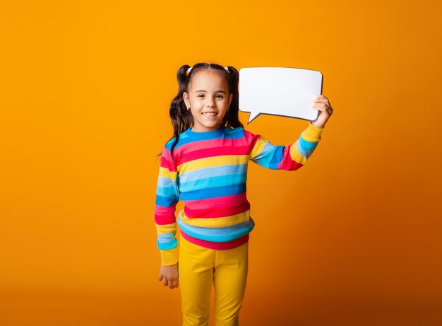 Retrato de una niña sosteniendo una nube de papel vacía reflexionando sobre una idea.