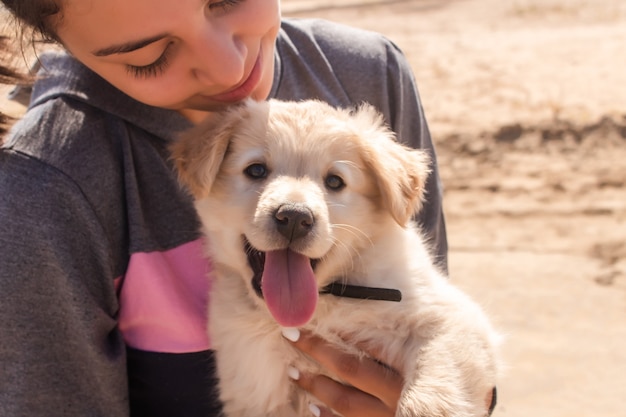 Retrato de una niña con su cachorro en la playa.