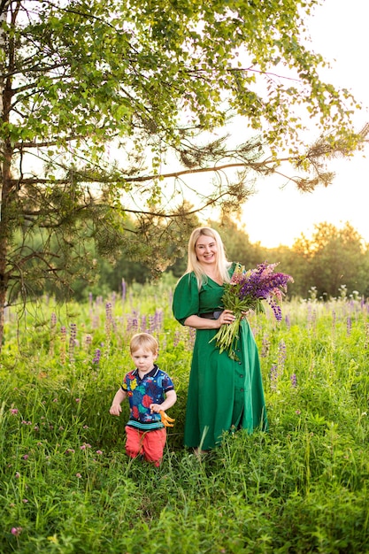 Retrato de una niña y su hijo en un campo floreciente bajo el sol al atardecer