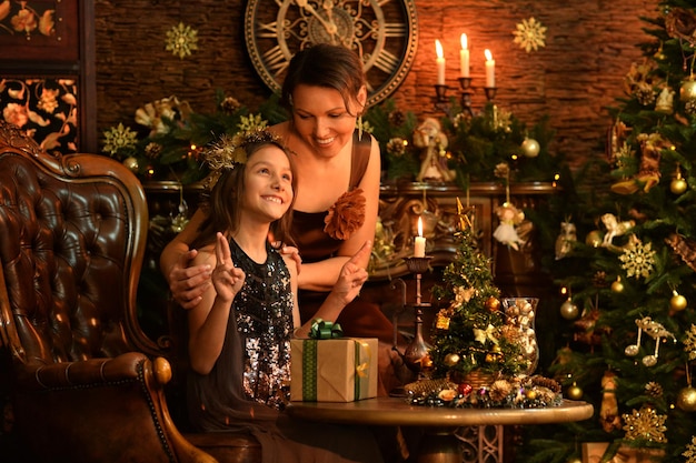 Retrato de niña con su madre con regalos de Navidad