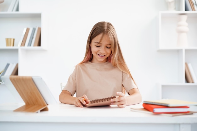 Retrato de una niña con tableta digital en casa