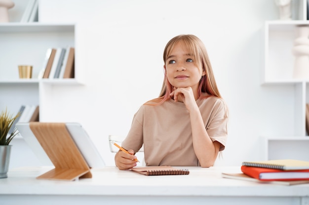 Retrato de una niña con tableta digital en casa