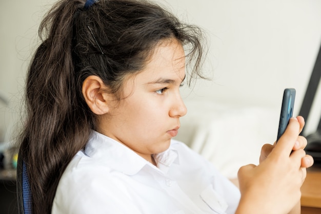 Retrato de una niña con un teléfono inteligente