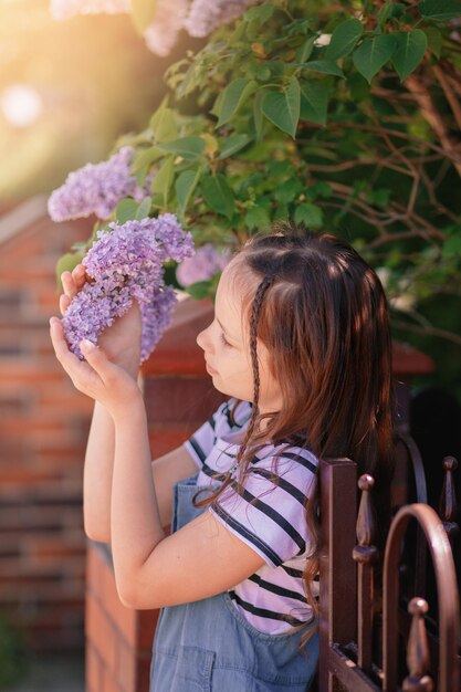 retrato, de, niña, tenencia, floreciente, liliac, flores, adorable, niño, niño, aire libre, en, cálido, primavera, día, vertical