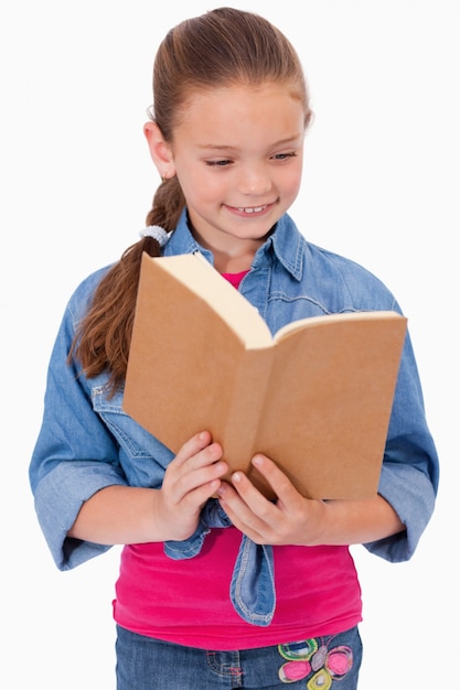 Retrato de una niña tranquila leyendo un libro