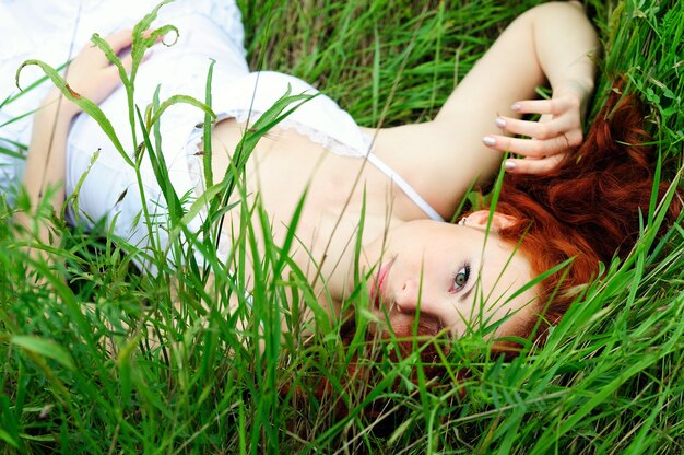 Retrato de niña, tumbado en el campo de hierba.