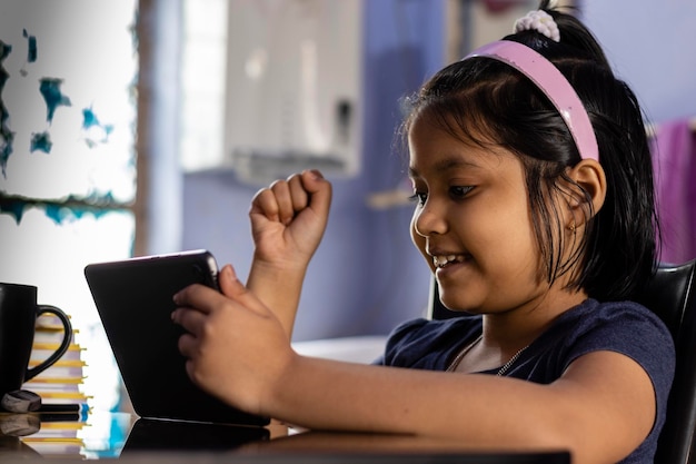 Foto retrato de una niña usando un teléfono móvil