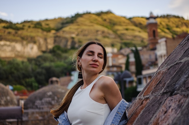 Foto retrato de una niña en vestido blanco con ciudad