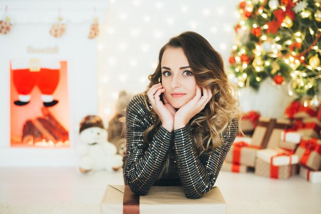 Retrato de una niña en un vestido de noche en el fondo de las decoraciones navideñas