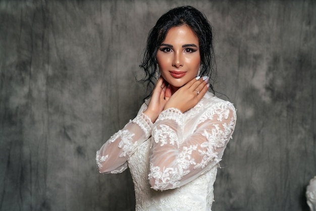 Retrato de una niña en un vestido de novia sobre un fondo gris