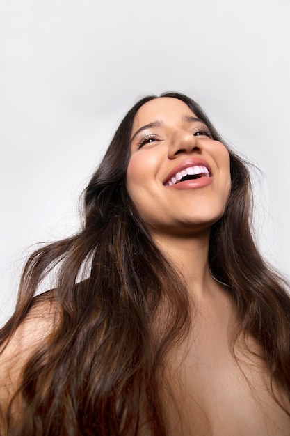 Retrato de niña vista desde abajo con una gran sonrisa y hermosos dientes