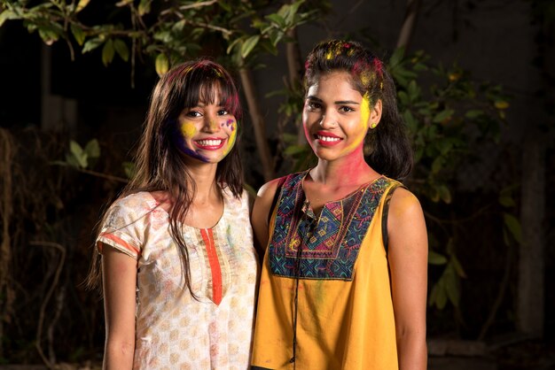 Retrato de niñas felices divirtiéndose con polvo de colores en el festival de colores de Holi