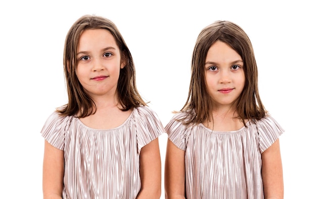 Retrato de niñas gemelas contra un fondo blanco