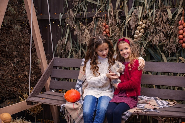 retrato de niñas novias en el otoño con un conejo en sus manos cerca de su casa fam