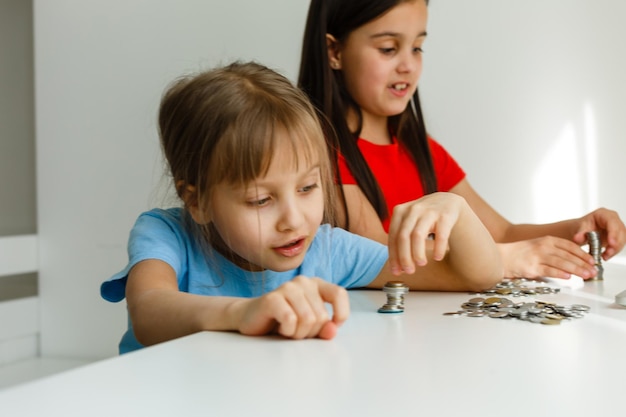 Retrato de niñas sentadas a la mesa y calculando dinero