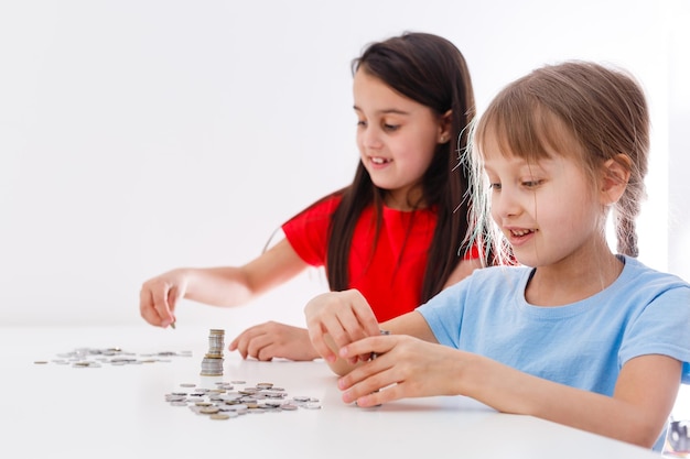 Retrato de niñas sentadas a la mesa y calculando dinero