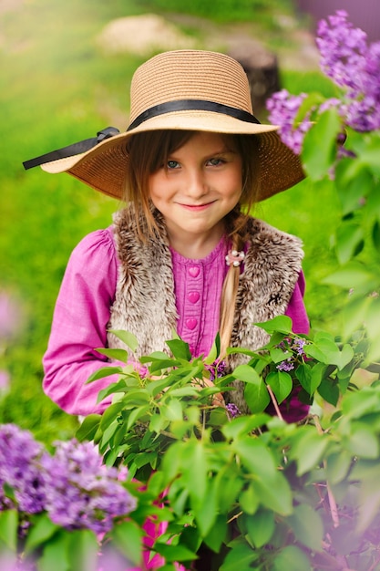 Retrato de una niñita astuta e intrigante con ropa informal pensando en una broma astuta y un niño desobediente sonriente que tiene planes astutos y engañosos en mente Jardín al aire libre con fondo morado