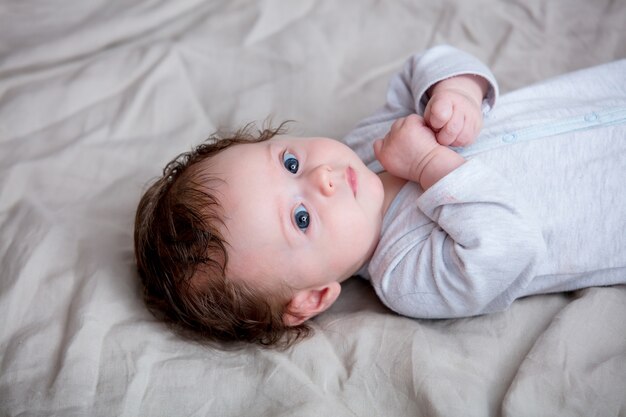 Retrato de niño acostado en la cama.